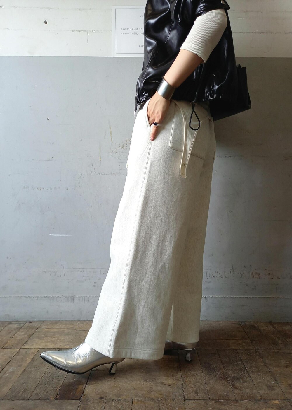 ブラック系のブルゾン、ホワイト系のTシャツ/カットソー、ブラック系のショルダーバッグを着用したレディースの秋コーディネートの7枚目の写真