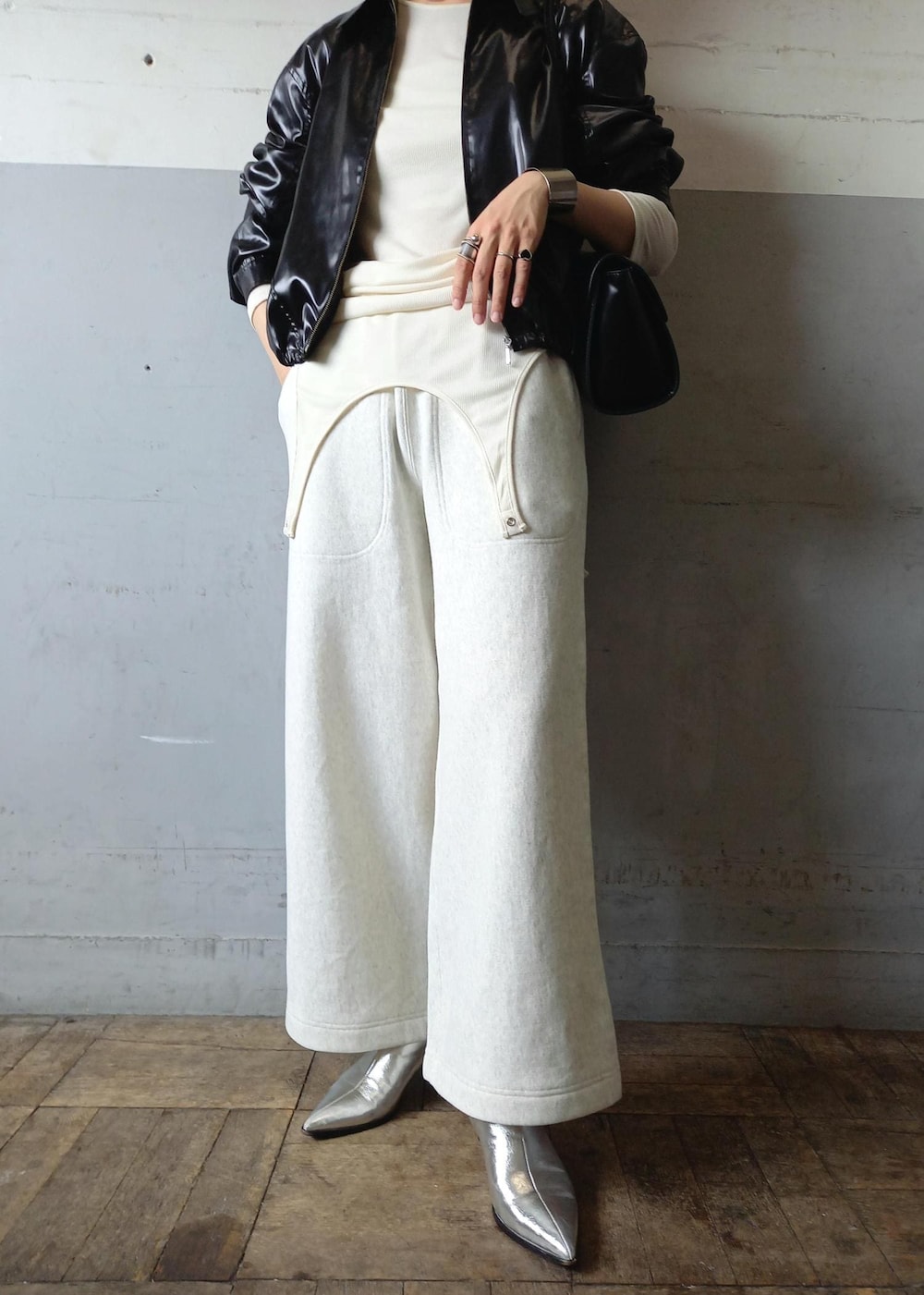 ブラック系のブルゾン、ホワイト系のTシャツ/カットソー、ブラック系のショルダーバッグを着用したレディースの秋コーディネートの6枚目の写真