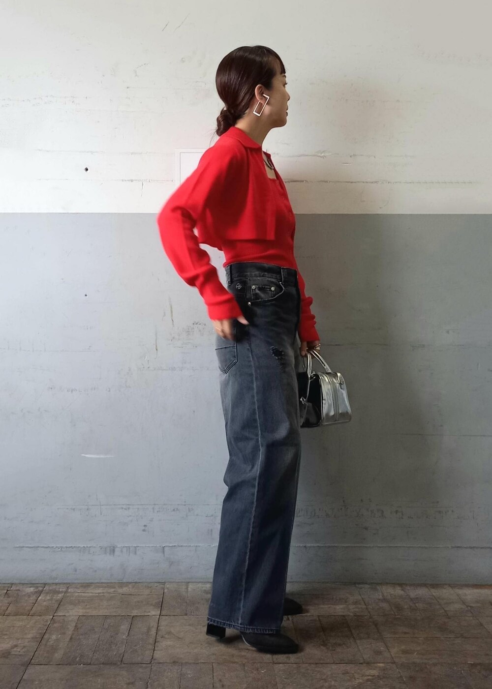 レッド系のカーディガン/ボレロ、ブラック系のデニムパンツ、シルバー系のショルダーバッグを着用したレディースの秋コーディネートの2枚目の写真