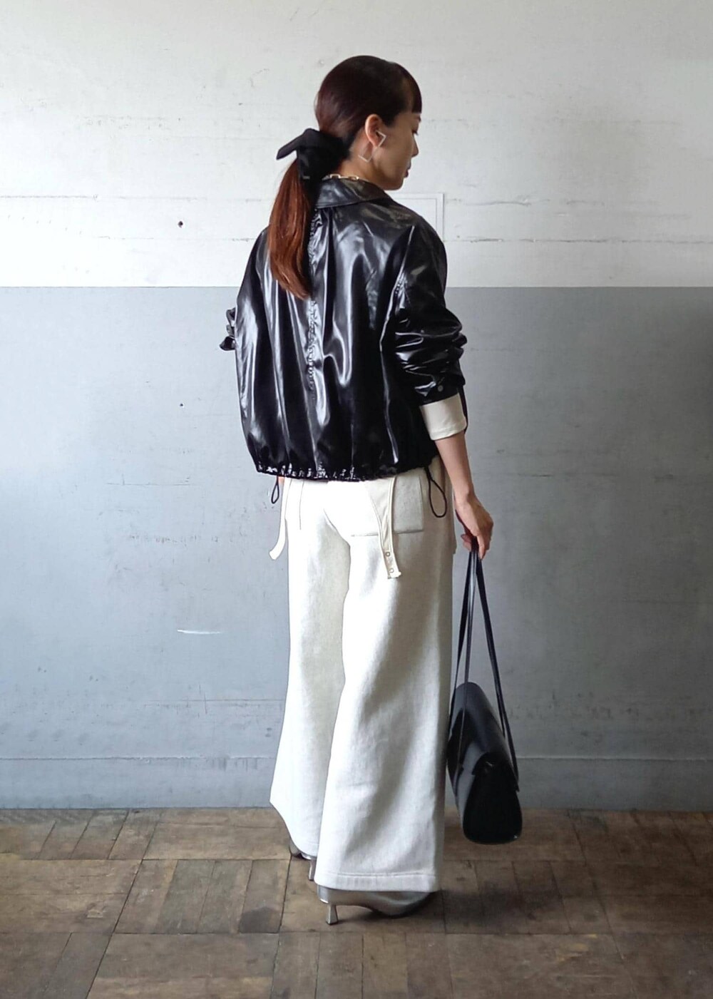ブラック系のブルゾン、ホワイト系のTシャツ/カットソー、ブラック系のショルダーバッグを着用したレディースの秋コーディネートの5枚目の写真