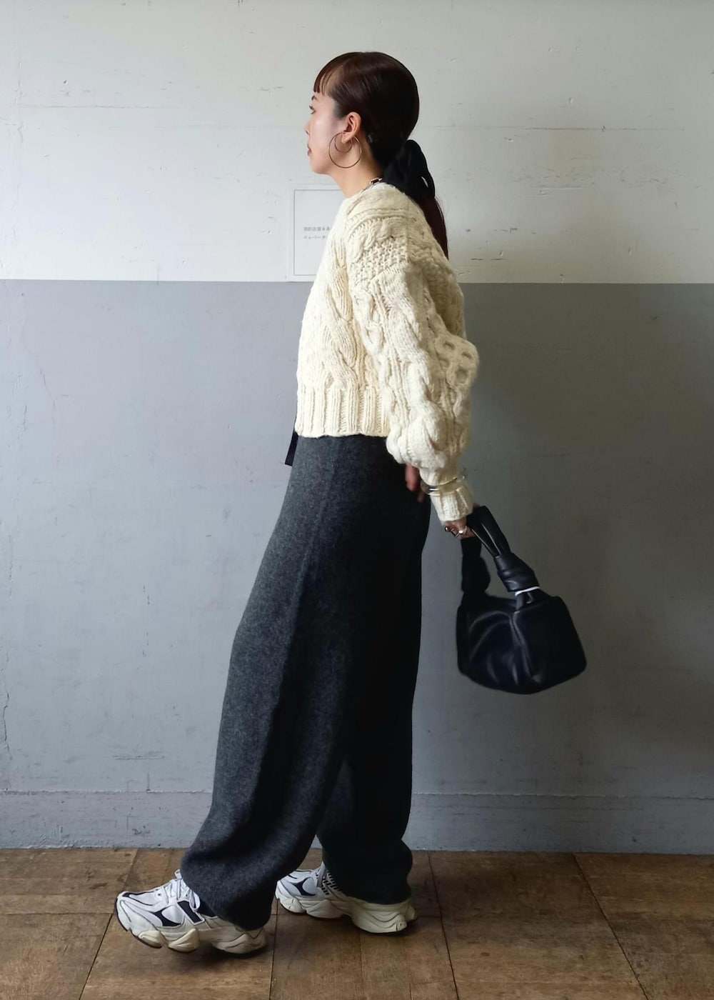 ブラック系のハンドバッグ、ホワイト系のカーディガン/ボレロ、グレー系のその他パンツを着用したレディースの秋コーディネートの5枚目の写真