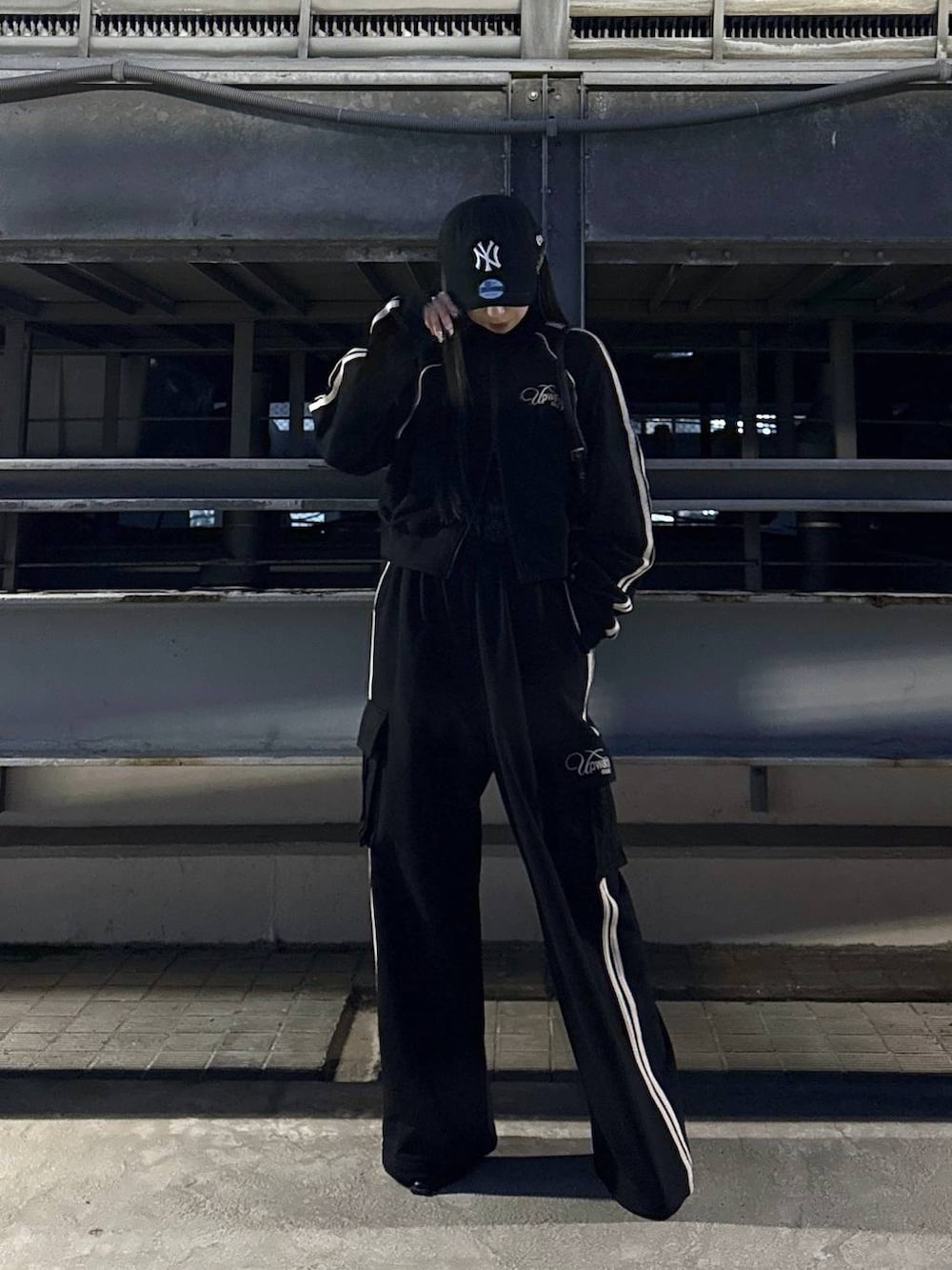 ブラック系のハンドバッグ、ブラック系のサンダル、ブラック系のスウェットパンツを着用したレディースの冬コーディネートの3枚目の写真