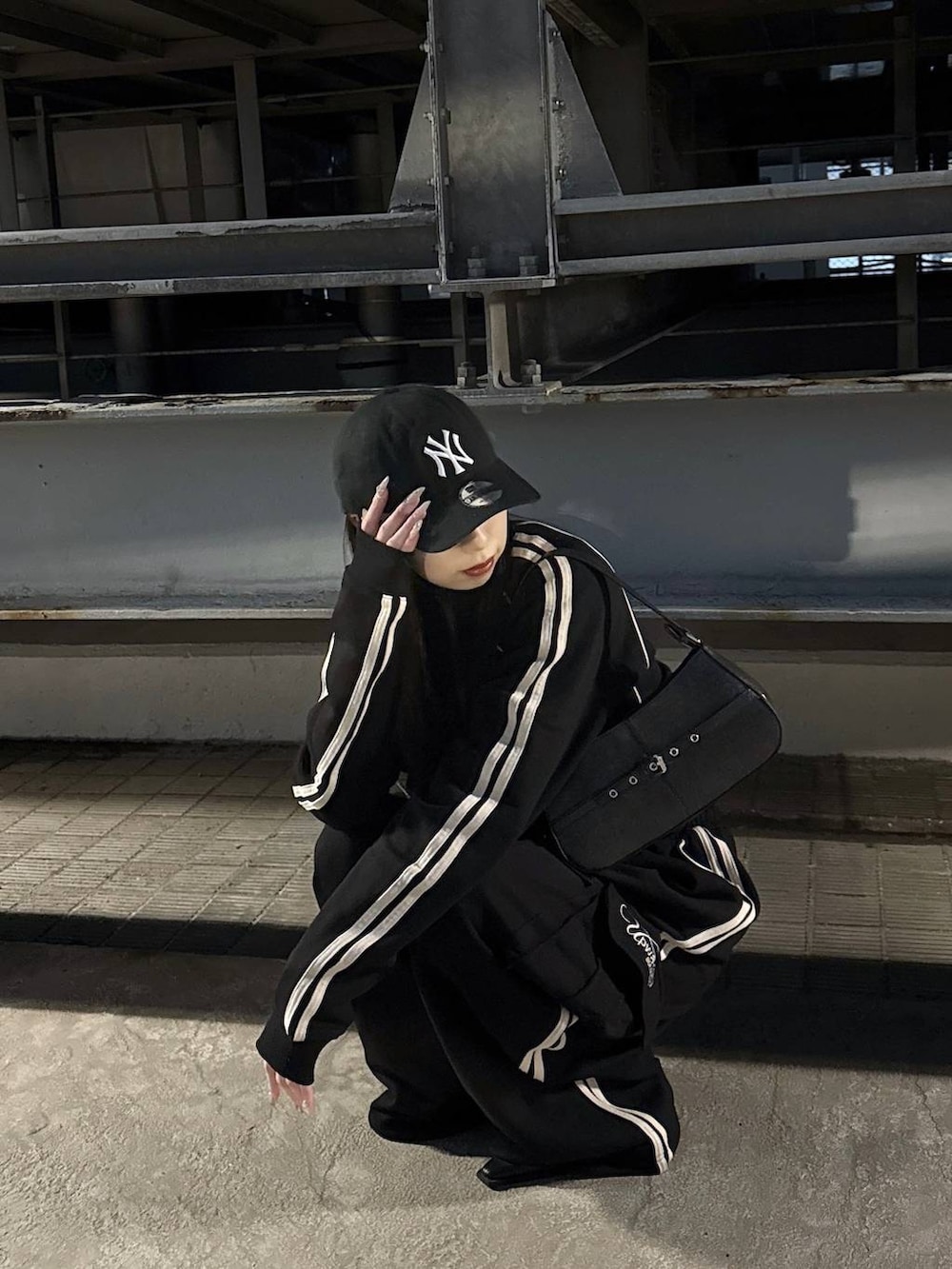 ブラック系のハンドバッグ、ブラック系のサンダル、ブラック系のスウェットパンツを着用したレディースの冬コーディネートの4枚目の写真