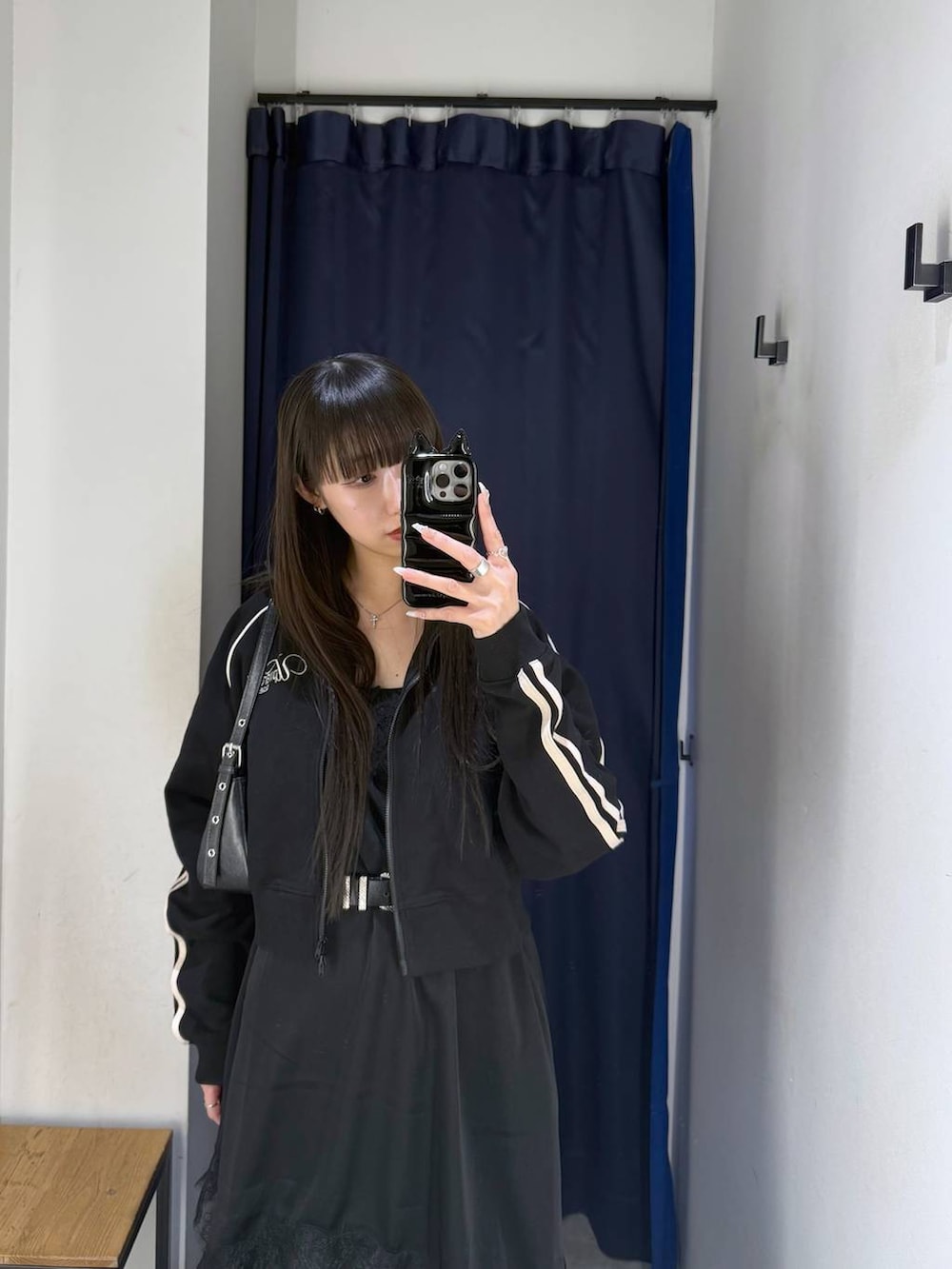 ブラック系のハンドバッグ、ブラック系のサンダル、ブラック系のチュニックを着用したレディースの春コーディネートの3枚目の写真