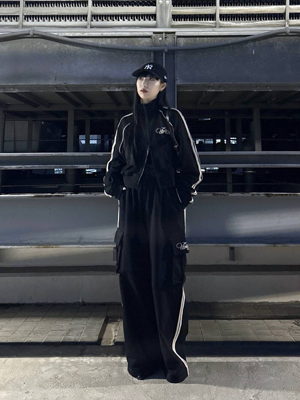 ブラック系のハンドバッグ、ブラック系のサンダル、ブラック系のスウェットパンツを着用したレディースの冬コーディネートの2枚目の写真