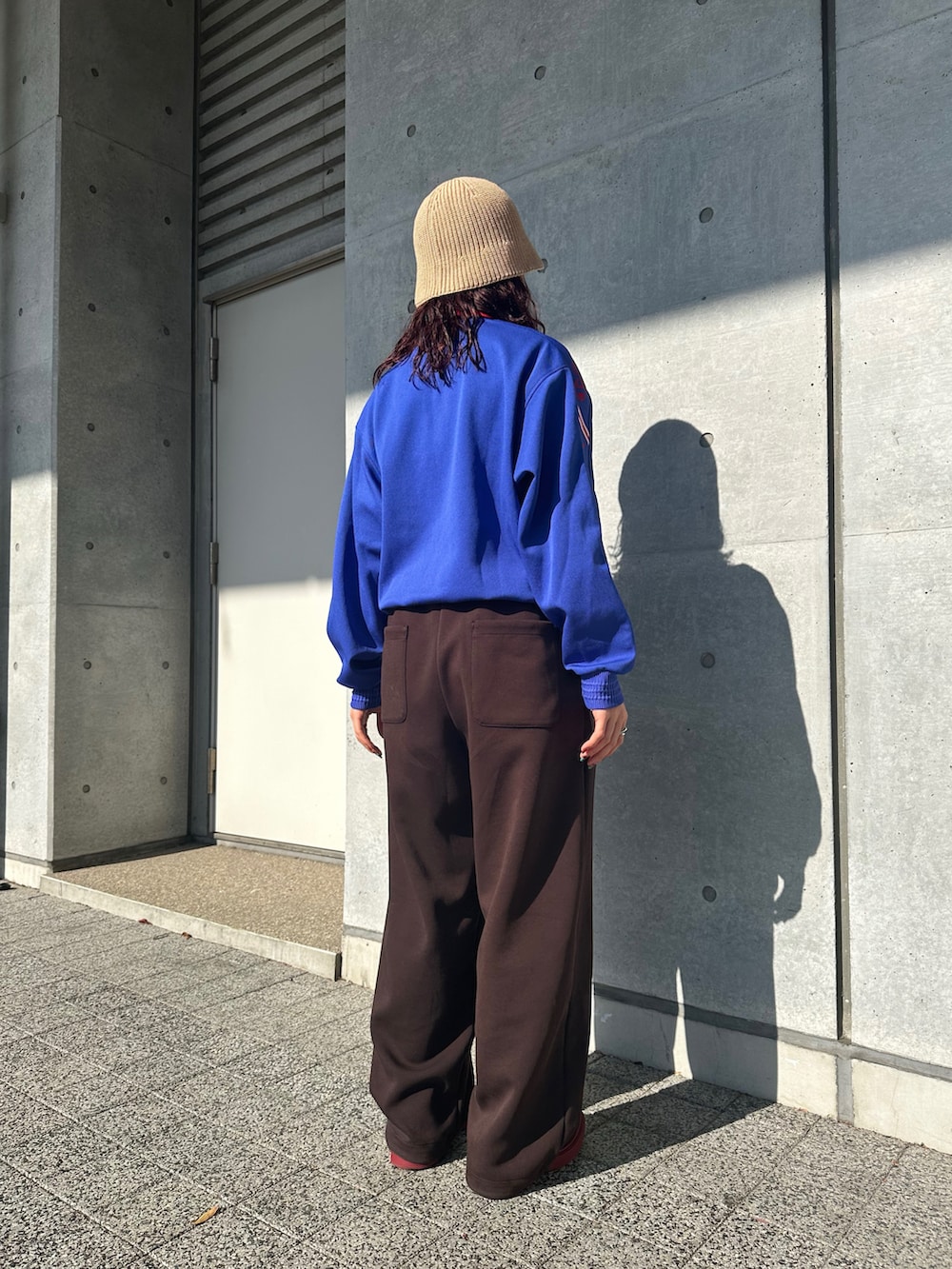 ブルー系のパーカー、ブラウン系のスウェットパンツ、レッド系のスリッポンを着用したレディースの冬コーディネートの2枚目の写真