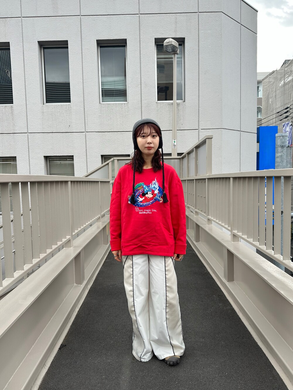 レッド系のスウェット、ホワイト系のその他パンツ、ベージュ系のシューズを着用したレディースの秋コーディネートの2枚目の写真