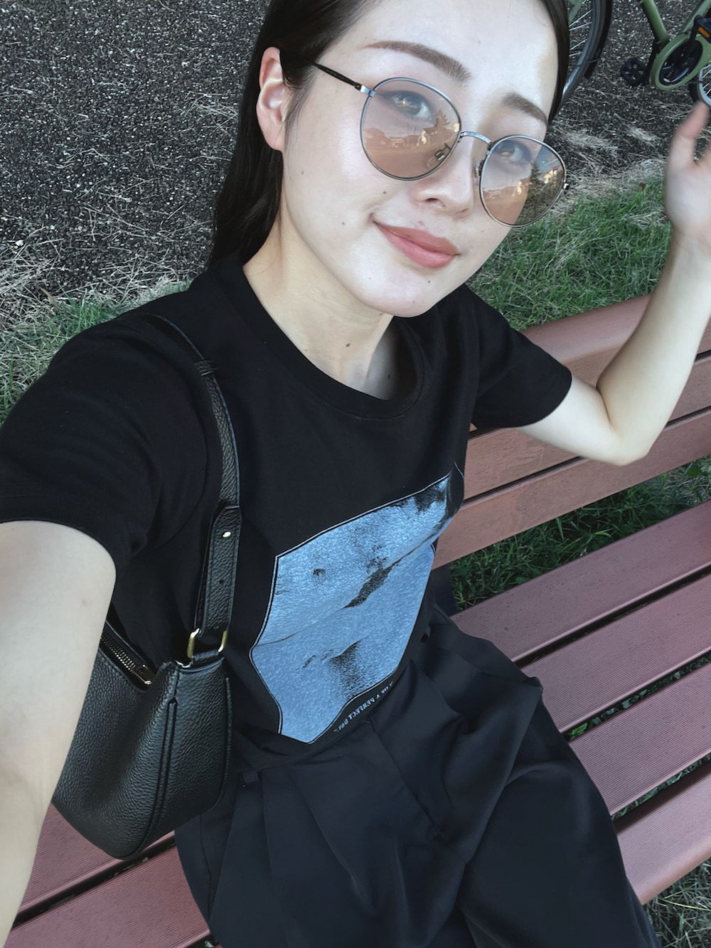 ブラック系のTシャツ/カットソー、ブラック系のバッグ、ブラック系のサンダルを着用したレディースの秋コーディネートの2枚目の写真