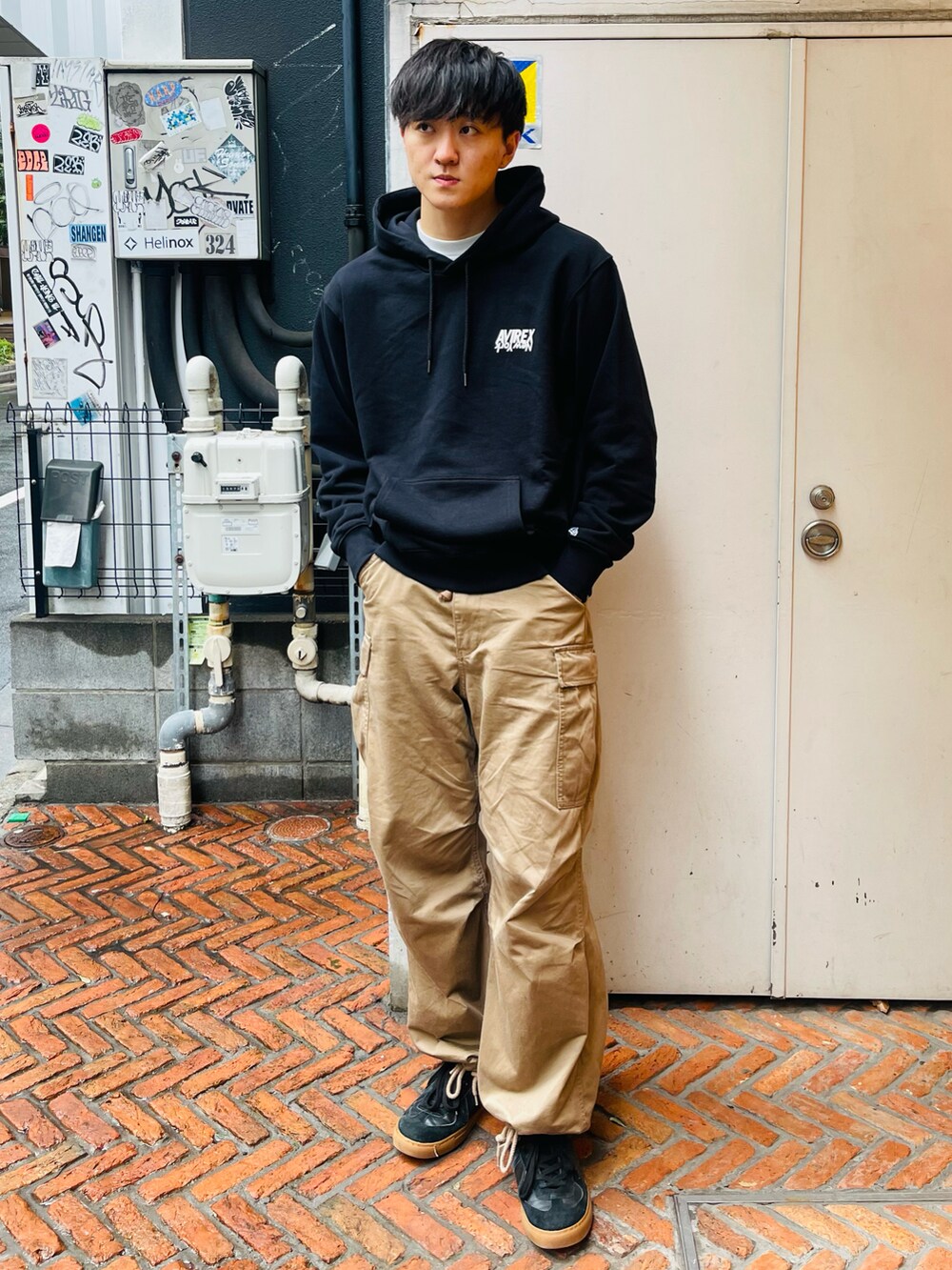 グレー系のパーカー、ベージュ系のカーゴパンツ、ホワイト系のスニーカーを着用したメンズの冬コーディネートの2枚目の写真