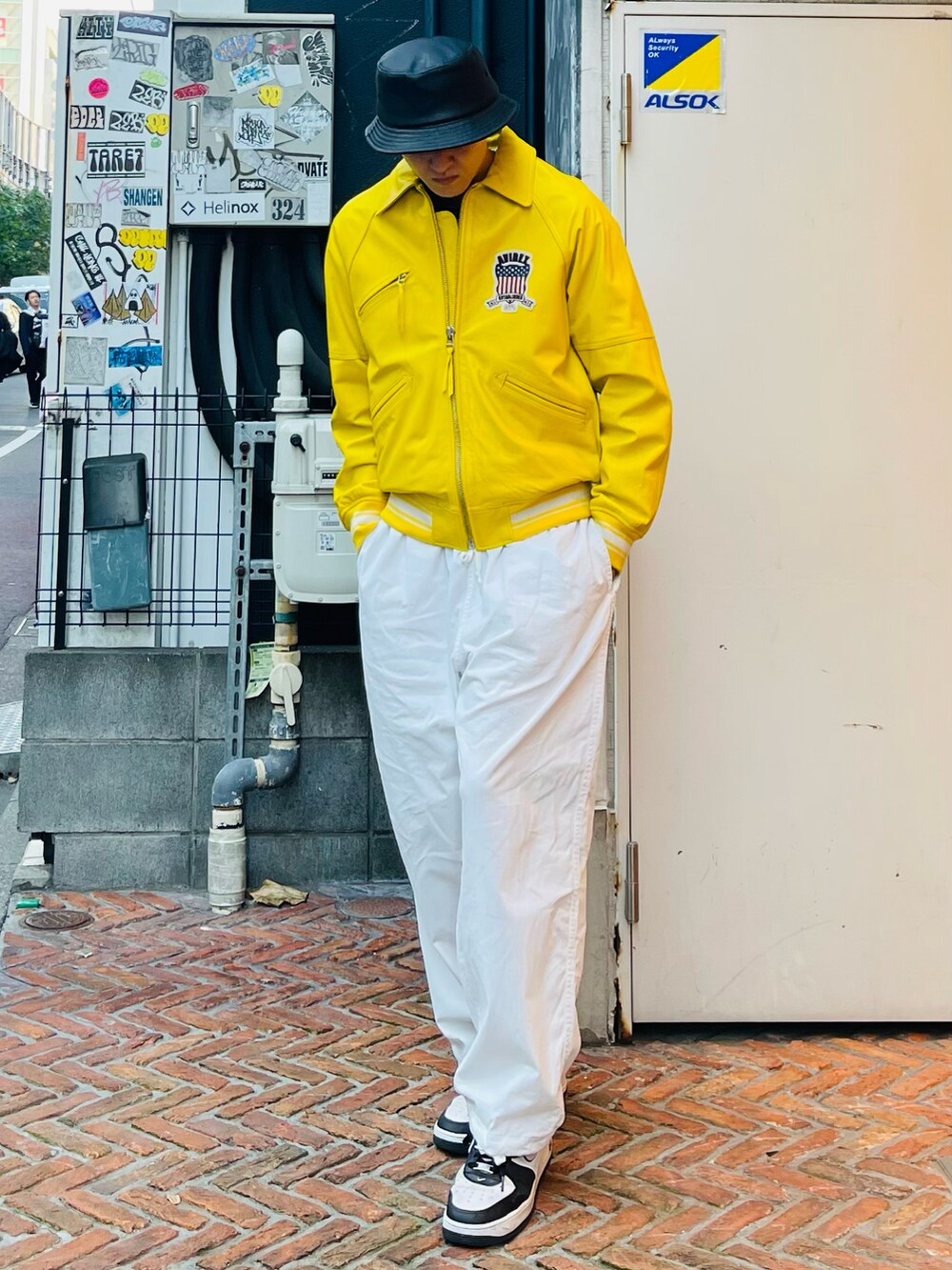 イエロー系のスタジャン、ホワイト系のその他パンツ、ブラック系のハットを着用したメンズの冬コーディネートの2枚目の写真