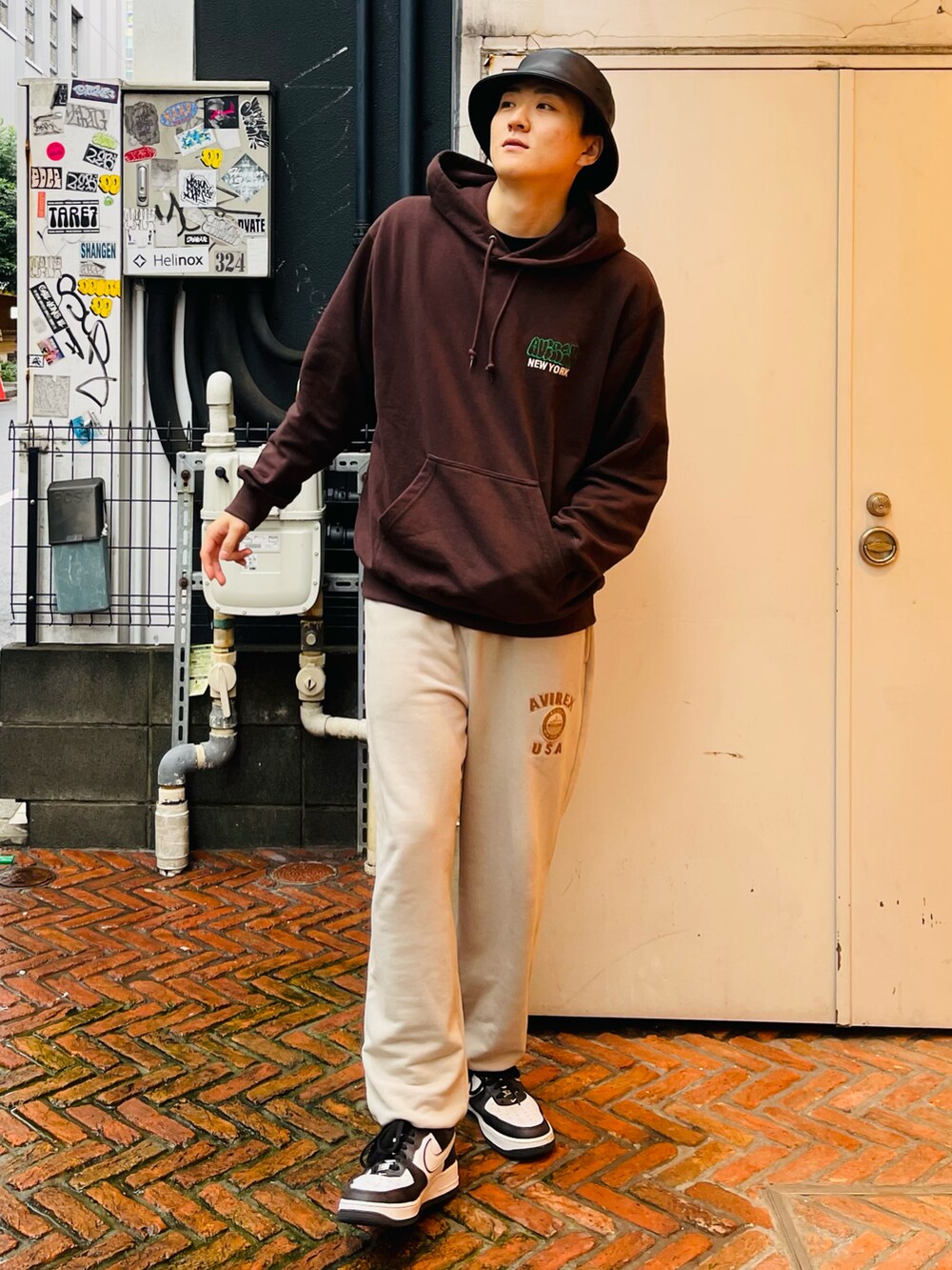 ブラウン系のパーカー、ベージュ系のスウェットパンツ、ブラック系のハットを着用したメンズの秋コーディネートの2枚目の写真