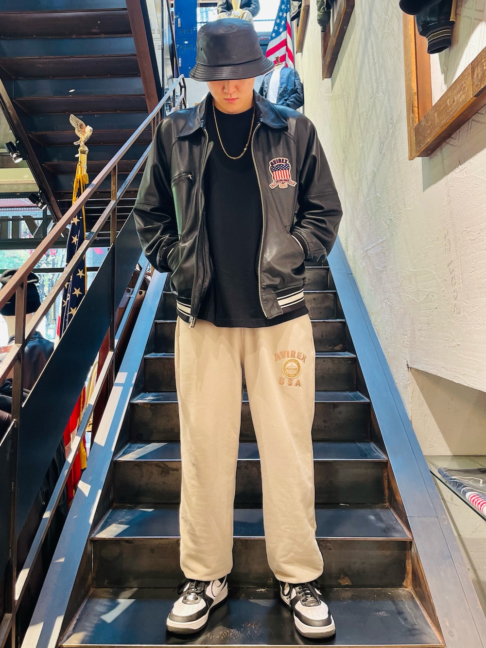 ブラック系のスタジャン、ベージュ系のスウェットパンツ、ブラック系のハットを着用したメンズの秋コーディネートの2枚目の写真