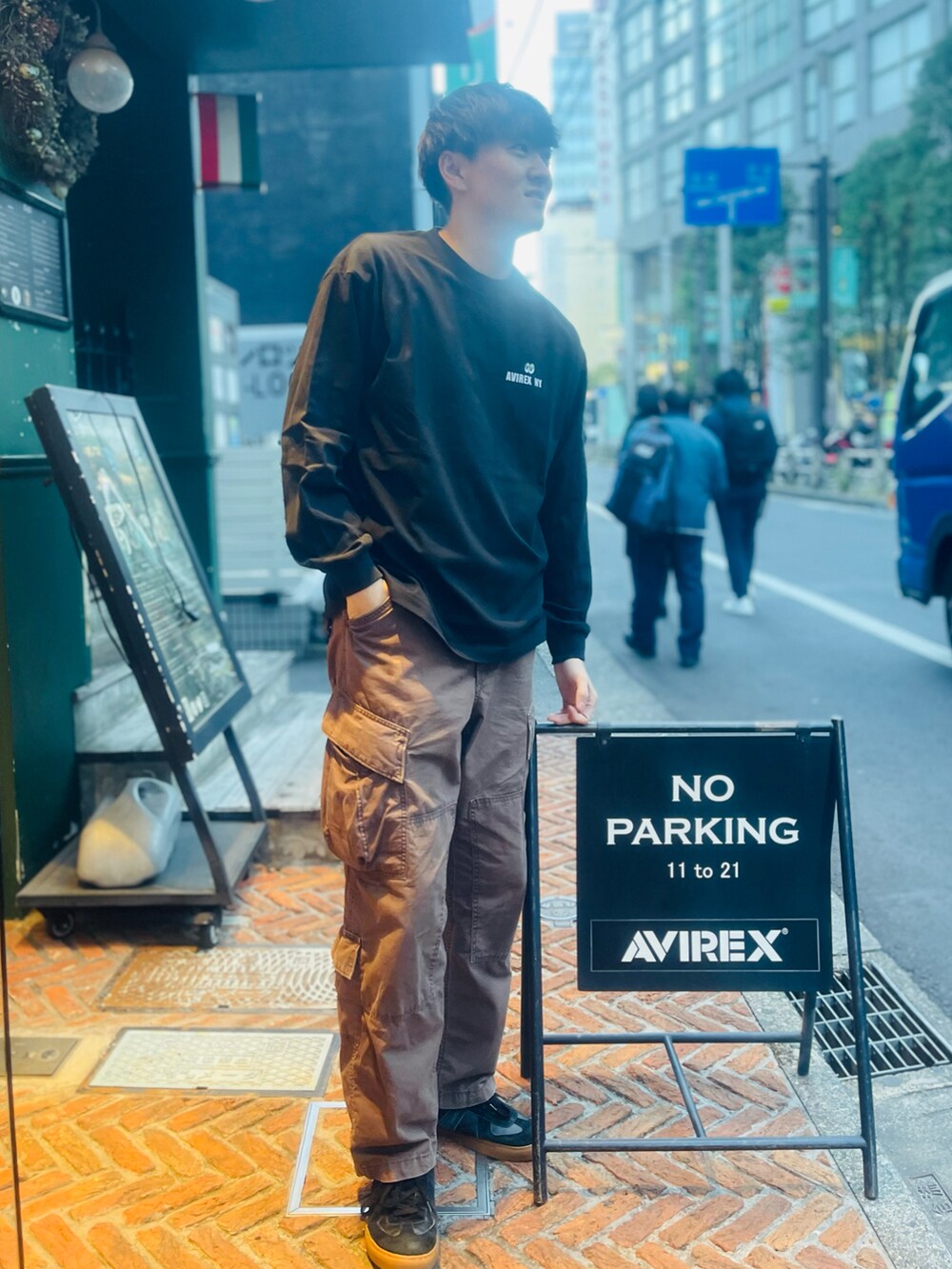 ブラック系のTシャツ/カットソー、ブラウン系のカーゴパンツ、ホワイト系のスニーカーを着用したメンズの冬コーディネートの2枚目の写真