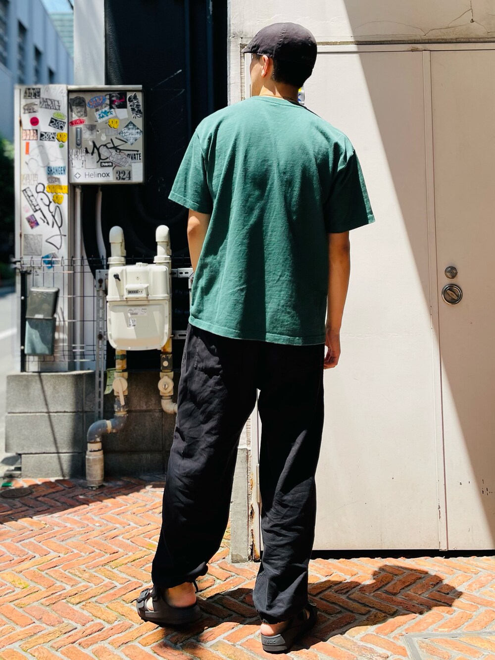 グリーン系のTシャツ/カットソー、ブラック系のその他パンツ、ブラック系のサンダルを着用したメンズの夏コーディネートの2枚目の写真