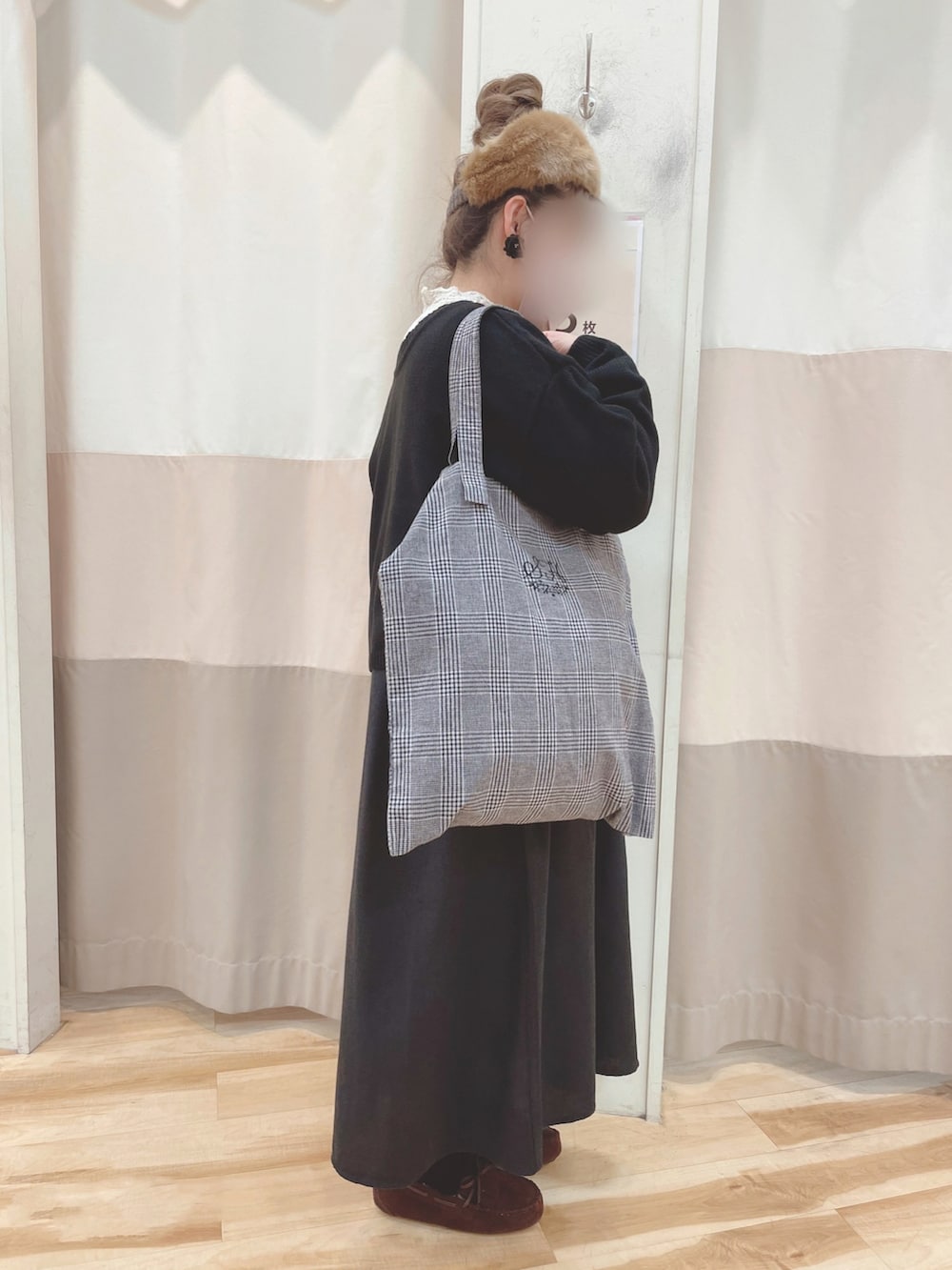 ブラウン系のモカシン/デッキシューズ、ブラック系のカーディガン/ボレロ、ブラック系のワンピースを着用したレディースの冬コーディネートの3枚目の写真