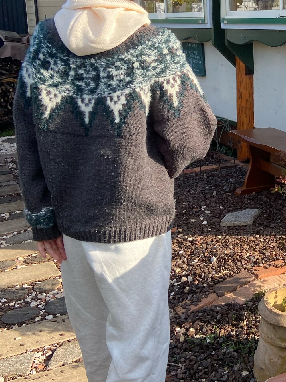 グレー系のニット/セーター、ホワイト系のスウェットパンツ、ホワイト系の帽子を着用したレディースの秋コーディネートの2枚目の写真