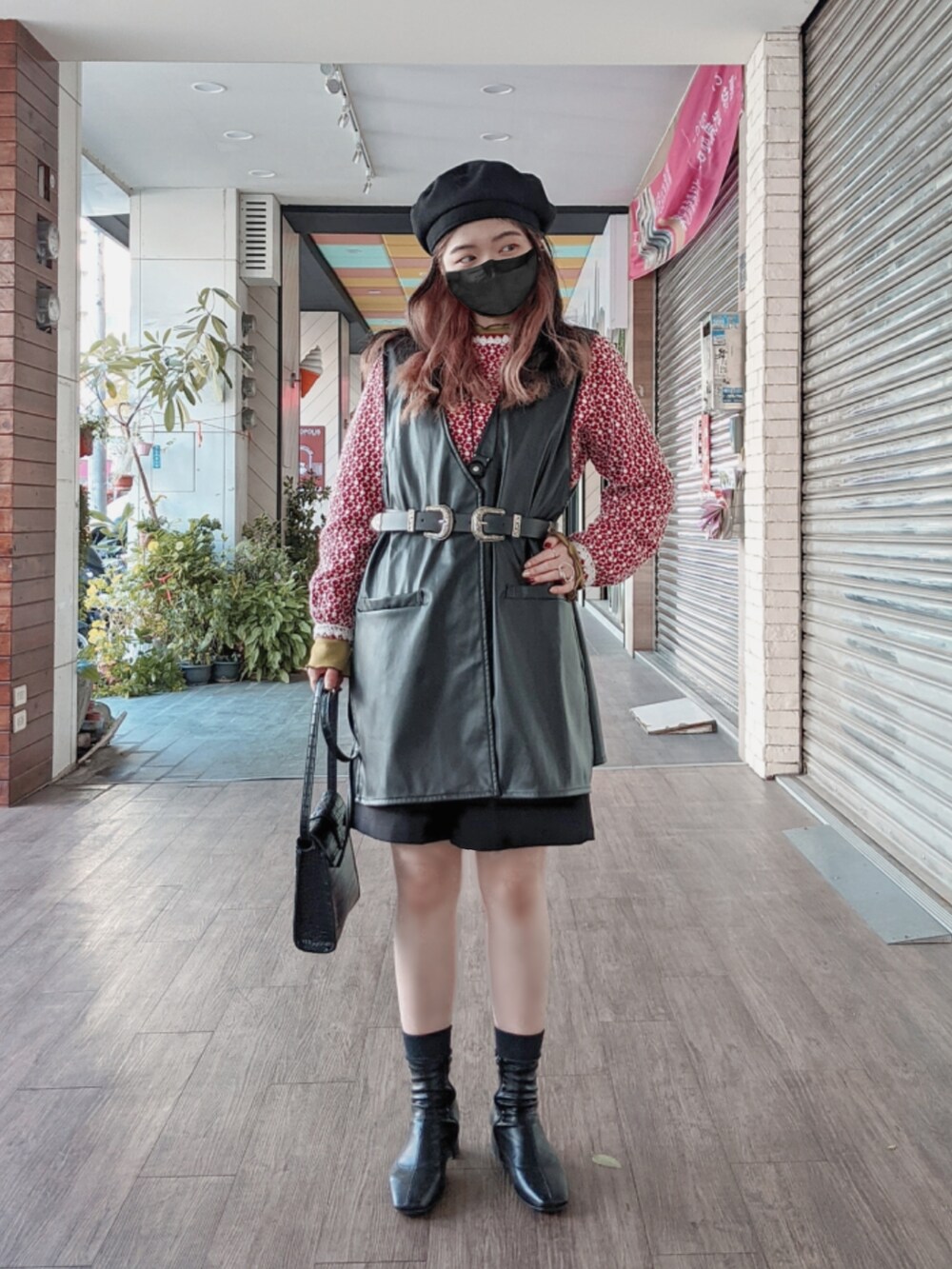 ブラック系のショルダーバッグ、ブラック系のベスト、グリーン系のTシャツ/カットソーを着用したレディースの冬コーディネートの2枚目の写真