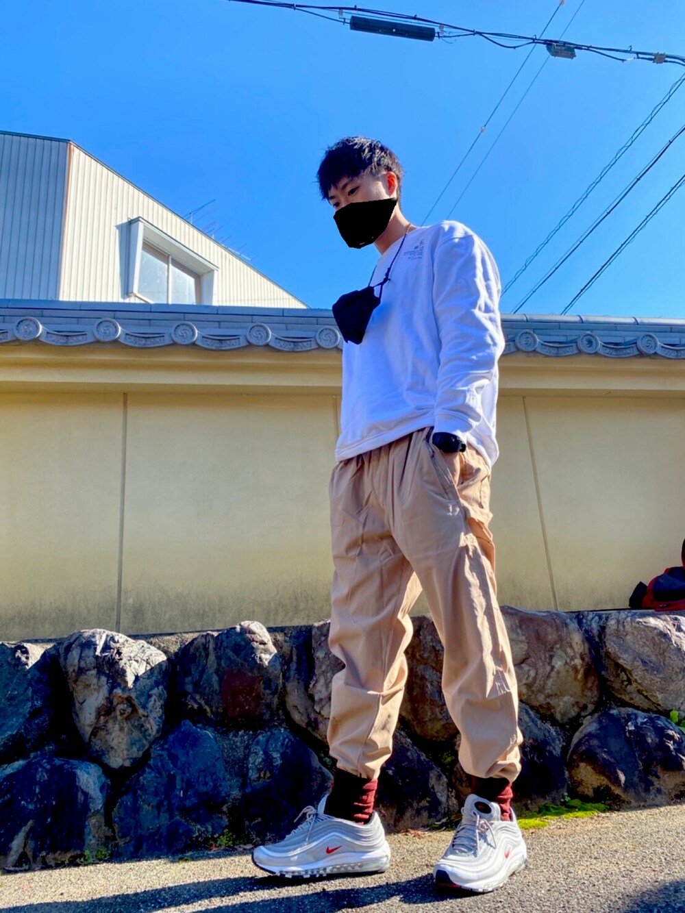 レッド系のダウンジャケット/コート、ホワイト系のTシャツ/カットソー、シルバー系のスニーカーを着用したメンズの冬コーディネートの2枚目の写真