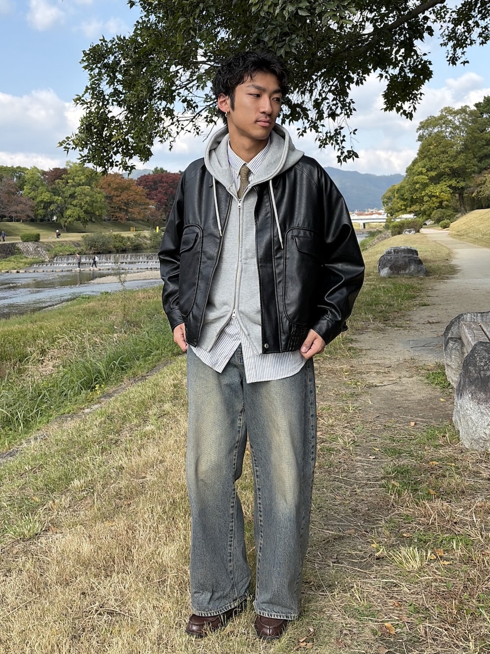 ブルー系のデニムパンツ、ブラウン系のローファー、ブラック系のブルゾンを着用したメンズの秋コーディネートの2枚目の写真