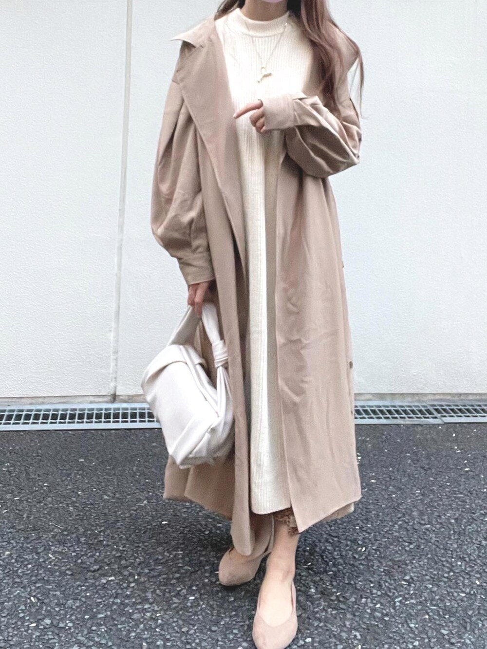 ベージュ系のニット/セーター、ベージュ系のパンプス、ベージュ系のトレンチコートを着用したレディースの秋コーディネートの2枚目の写真