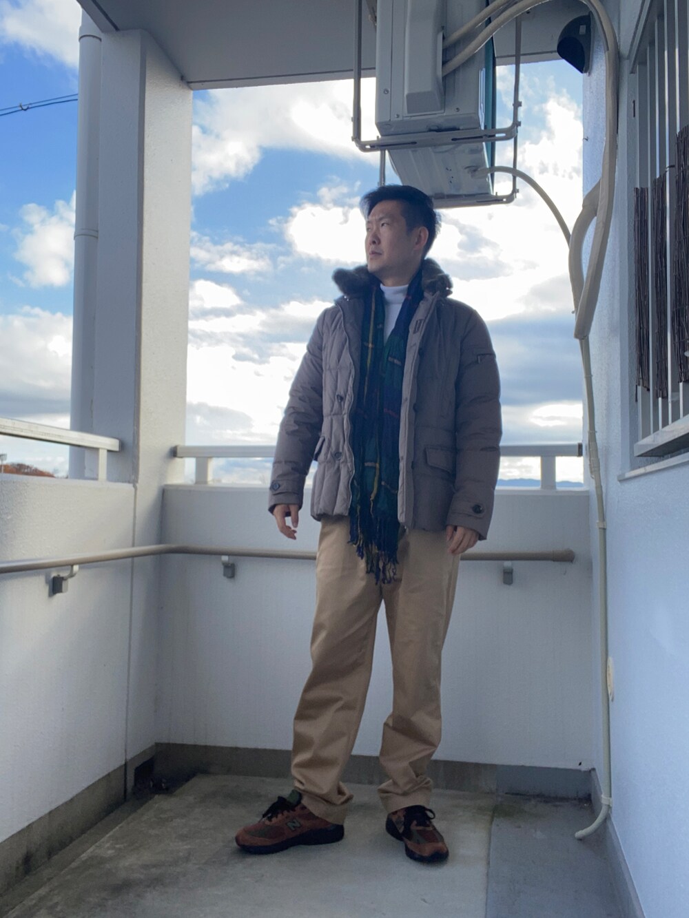 ベージュ系のダウンジャケット/コート、ベージュ系のチノパンツ、ブラウン系のスニーカーを着用したメンズの冬コーディネートの2枚目の写真