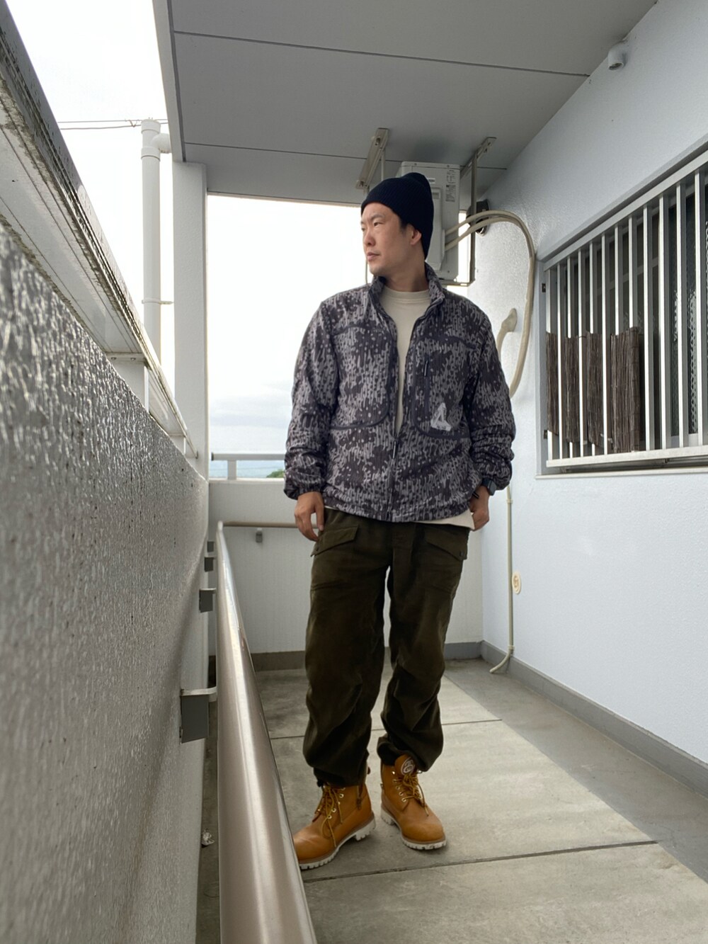 グレー系のジャケット/アウター、グリーン系のその他パンツ、ベージュ系のブーツを着用したメンズの春コーディネートの2枚目の写真