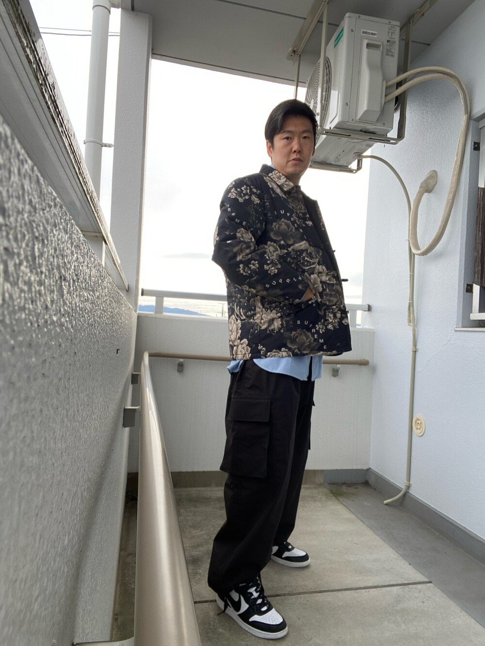 ブラック系のその他アウター、ブルー系のシャツ/ブラウス、ブラック系のその他パンツを着用したメンズの冬コーディネートの3枚目の写真