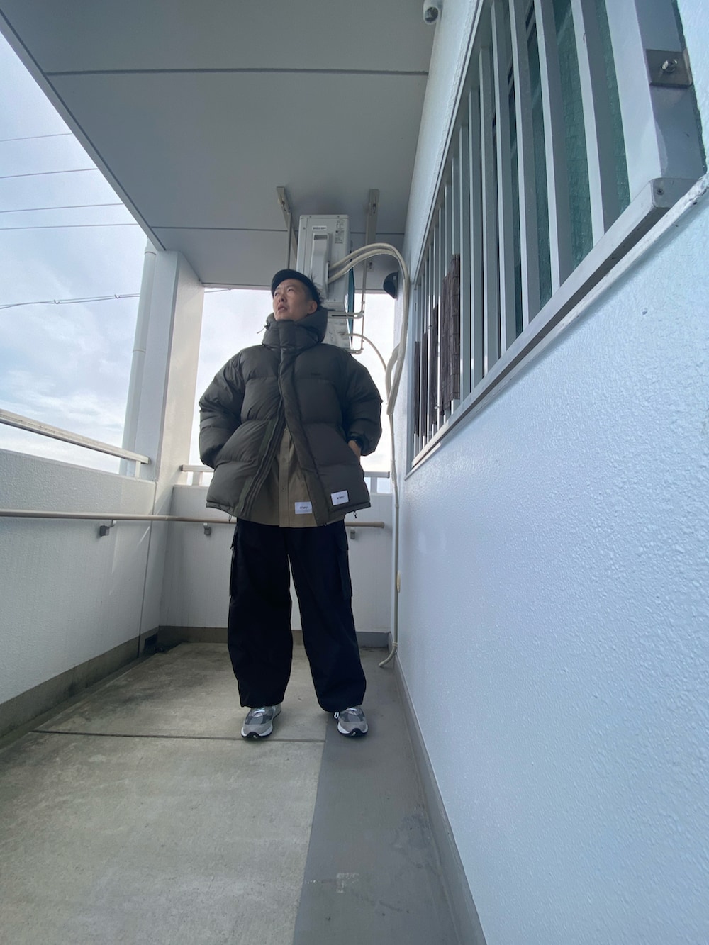 グリーン系のダウンジャケット/コート、ベージュ系のシャツ/ブラウス、ブラック系のその他パンツを着用したメンズの冬コーディネートの3枚目の写真