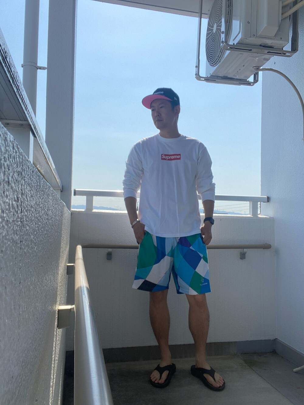 ホワイト系のTシャツ/カットソー、ブルー系のパンツ、ブラック系のサンダルを着用したメンズの春コーディネートの2枚目の写真