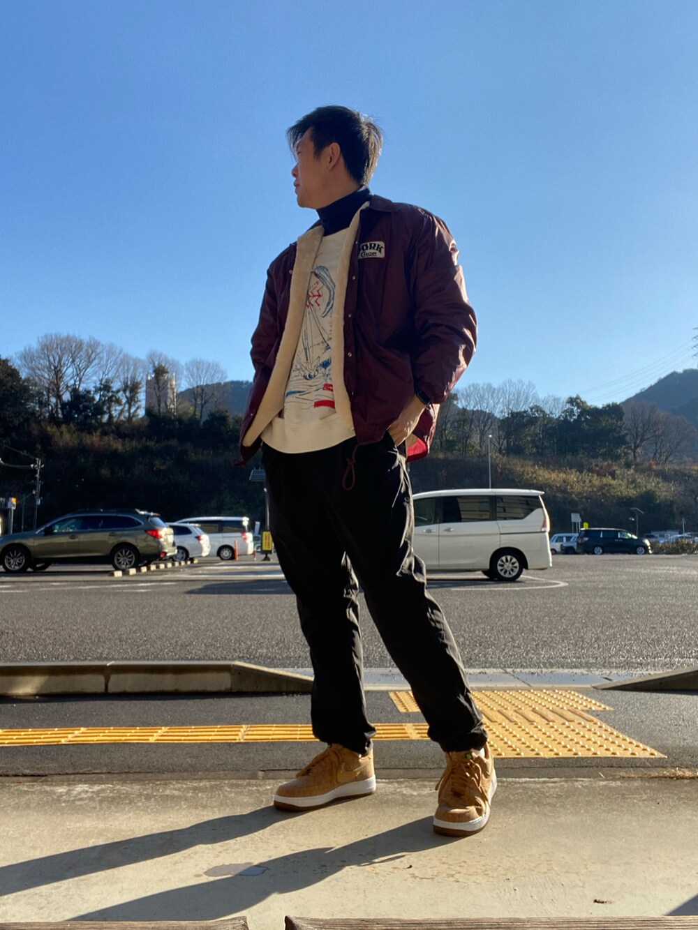 レッド系のジャケット/アウター、ブラック系のパンツ、イエロー系のスニーカーを着用したメンズの冬コーディネートの2枚目の写真