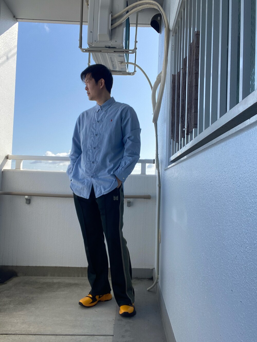 ブルー系のシャツ/ブラウス、グリーン系のスウェットパンツ、イエロー系のスニーカーを着用したメンズの春コーディネートの3枚目の写真