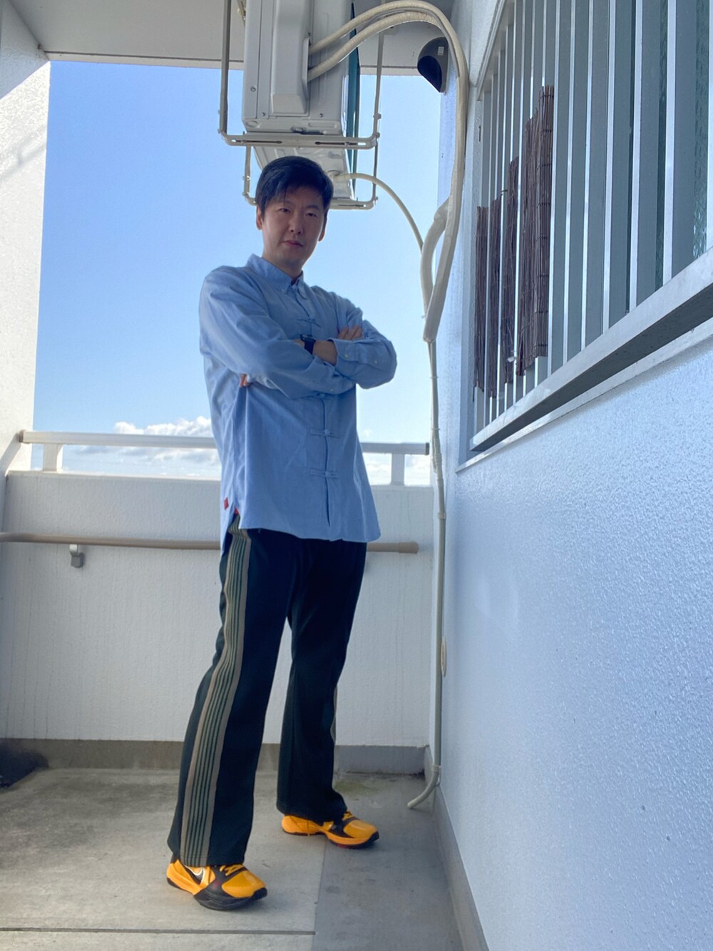 ブルー系のシャツ/ブラウス、グリーン系のスウェットパンツ、イエロー系のスニーカーを着用したメンズの春コーディネートの2枚目の写真