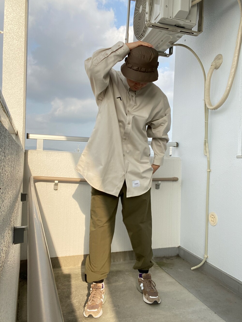 グレー系のシャツ/ブラウス、グリーン系のパンツ、ベージュ系のスニーカーを着用したメンズの春コーディネートの2枚目の写真