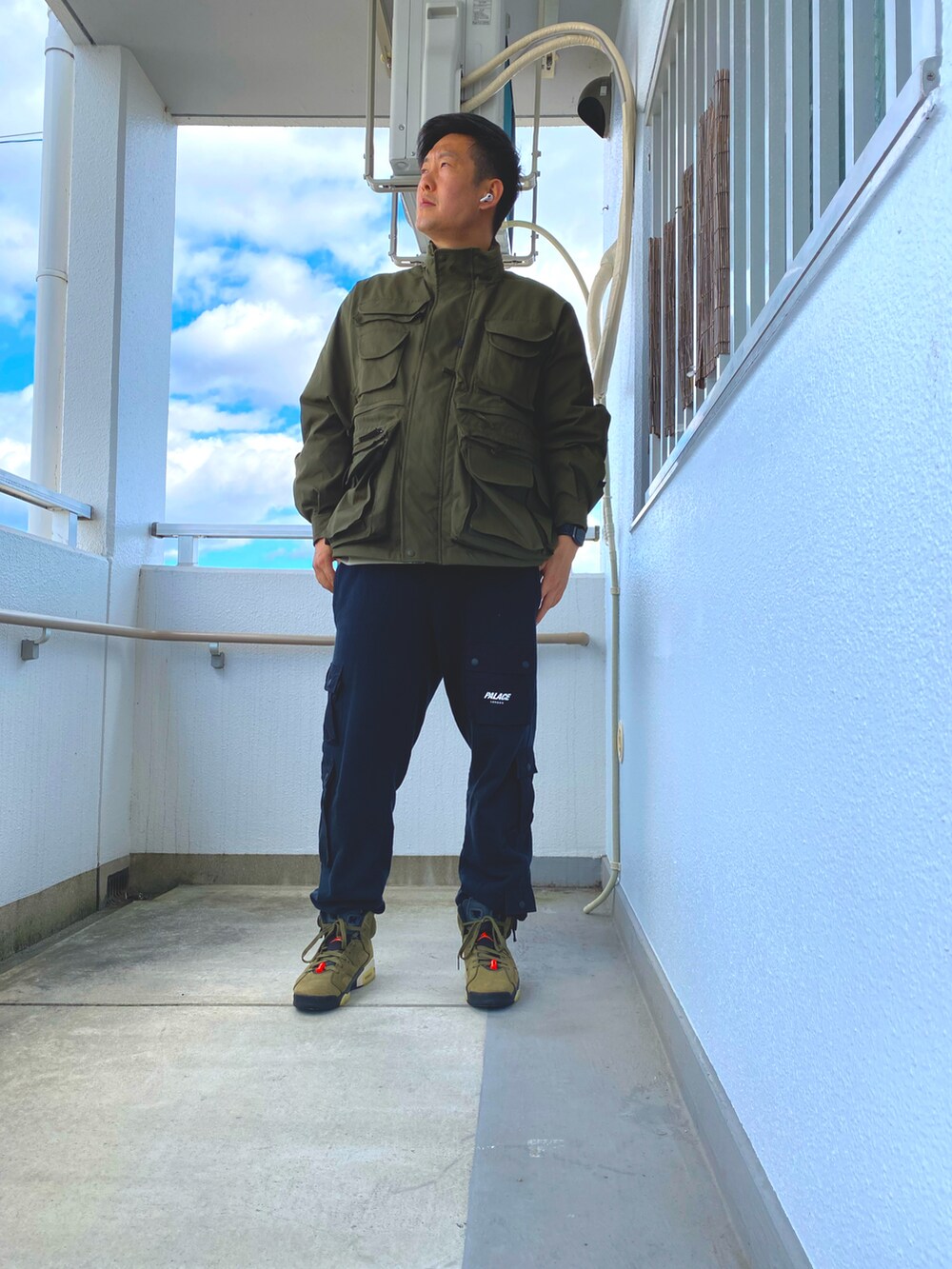 グリーン系のミリタリージャケット、ブラック系のスウェットパンツ、グリーン系のスニーカーを着用したメンズの冬コーディネートの2枚目の写真