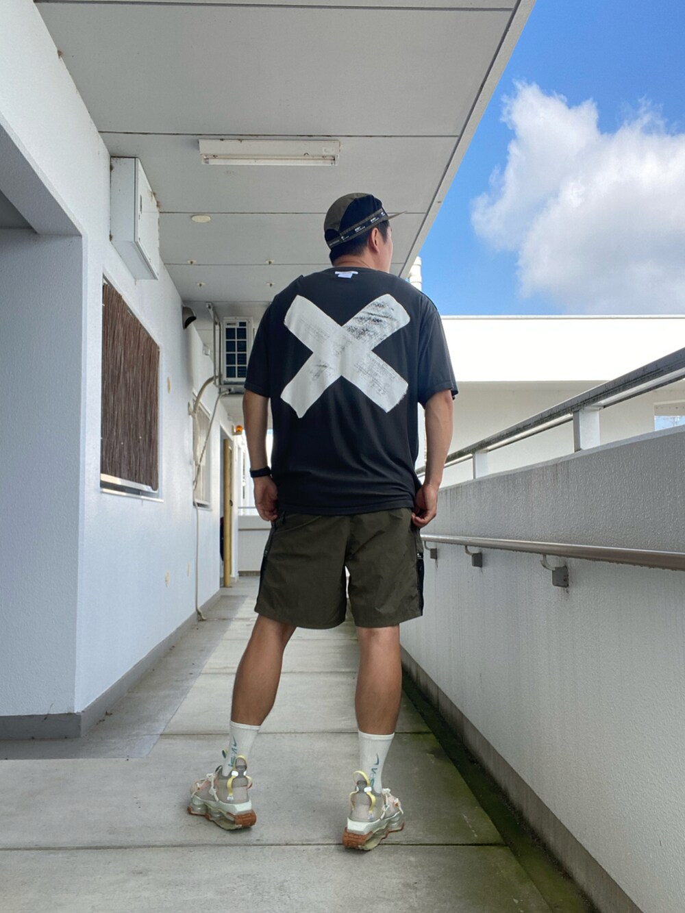 ブラック系のTシャツ/カットソー、グリーン系のパンツ、ベージュ系のスニーカーを着用したメンズの夏コーディネートの2枚目の写真