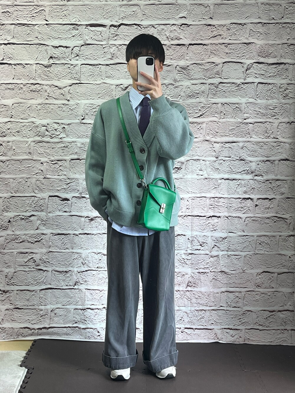 ブルー系のカーディガン/ボレロ、グレー系のデニムパンツ、ホワイト系のスニーカーを着用したメンズの春コーディネートの2枚目の写真