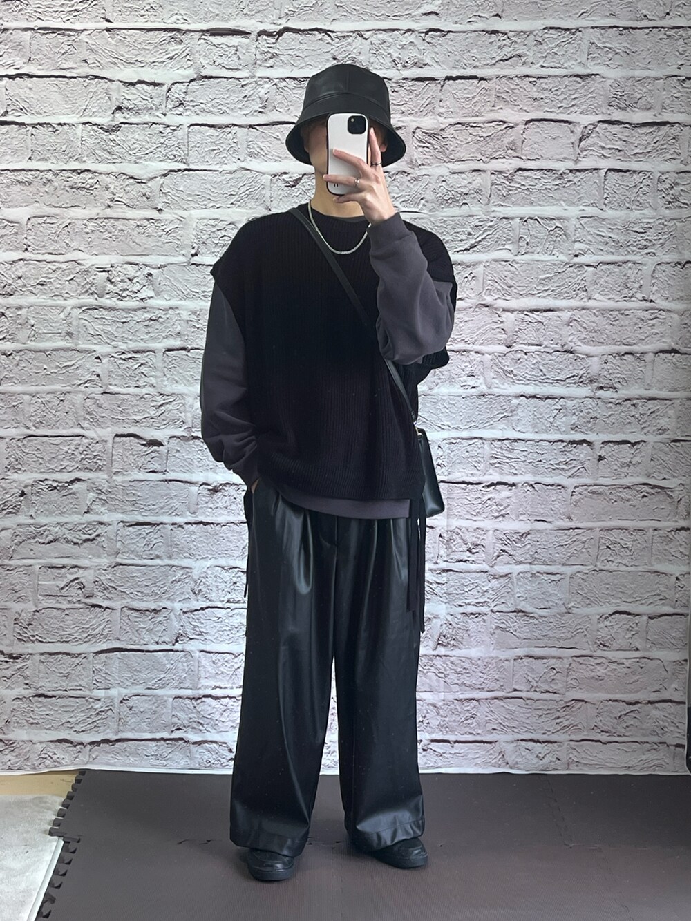 ブラック系のスニーカー、ブラック系のベストを着用したメンズの春コーディネートの2枚目の写真