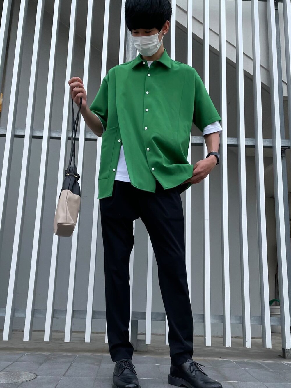 ブラック系のスラックス、ブラック系のドレスシューズ、ベージュ系のショルダーバッグを着用したメンズの夏コーディネートの2枚目の写真