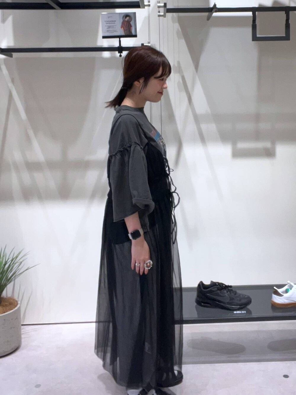 グレー系のスカート、ブラック系のスニーカー、グレー系のTシャツ/カットソーを着用したレディースの春コーディネートの2枚目の写真