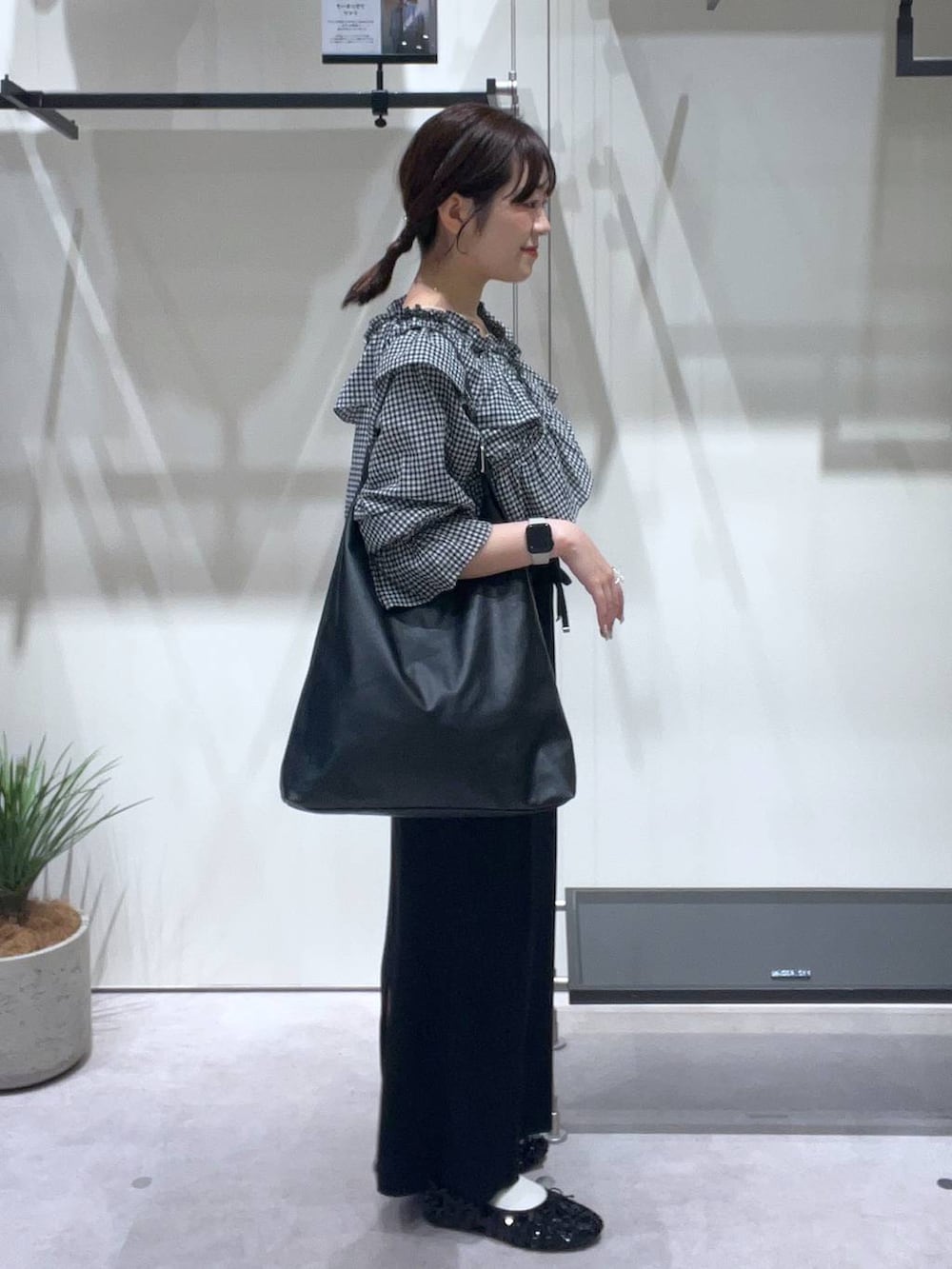 ブラック系のスカート、ブラック系のバレエシューズ、ホワイト系のキャミソールを着用したレディースの春コーディネートの2枚目の写真