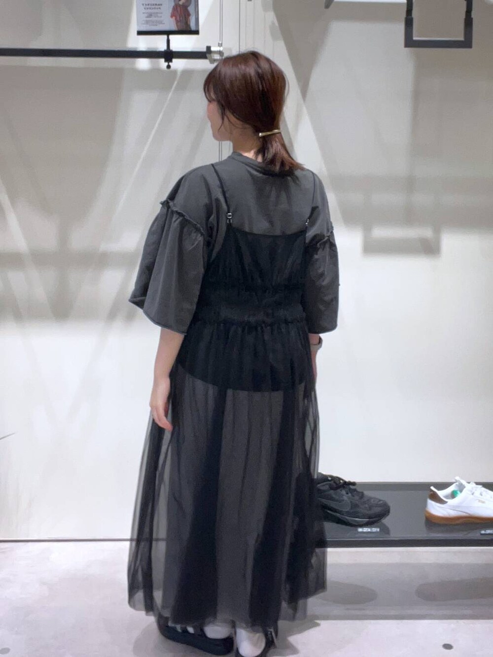 グレー系のスカート、ブラック系のスニーカー、グレー系のTシャツ/カットソーを着用したレディースの春コーディネートの3枚目の写真