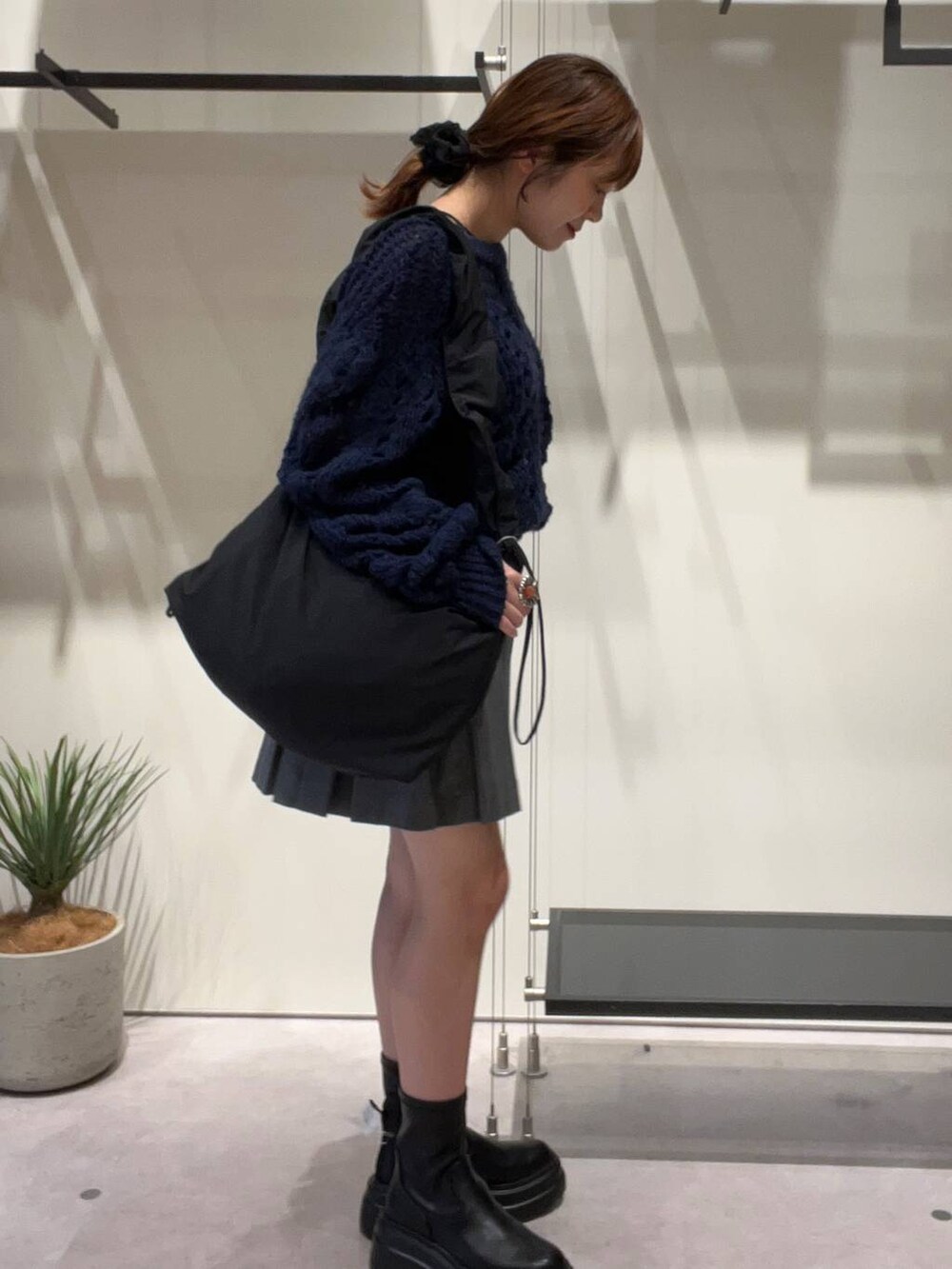 ブラック系のタンクトップ、ブラック系のショルダーバッグ、ブラック系のブーツを着用したレディースの秋コーディネートの2枚目の写真