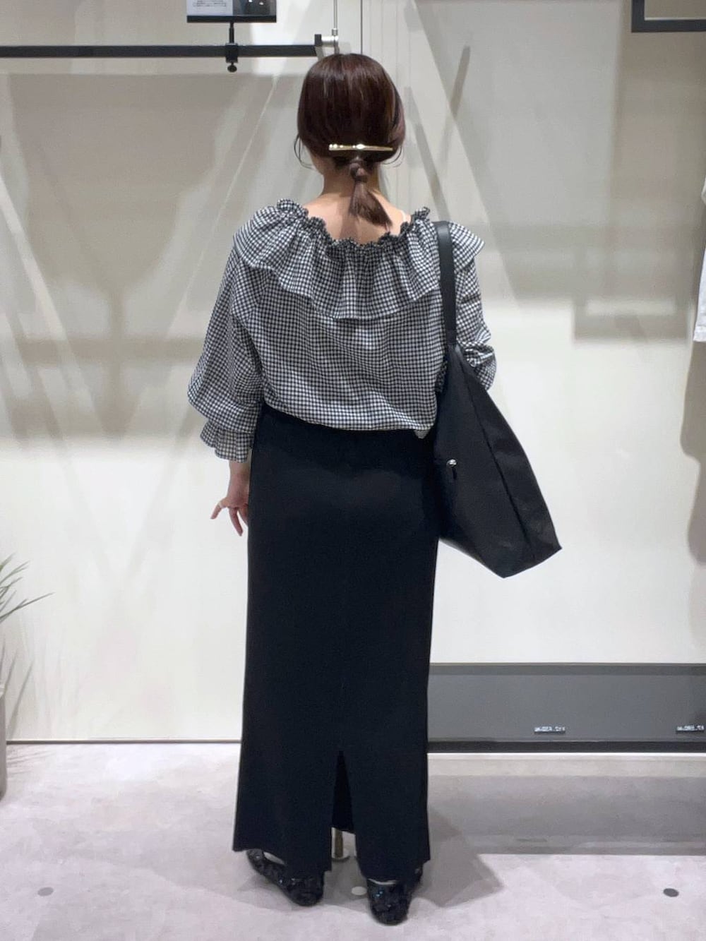 ブラック系のスカート、ブラック系のバレエシューズ、ホワイト系のキャミソールを着用したレディースの春コーディネートの3枚目の写真