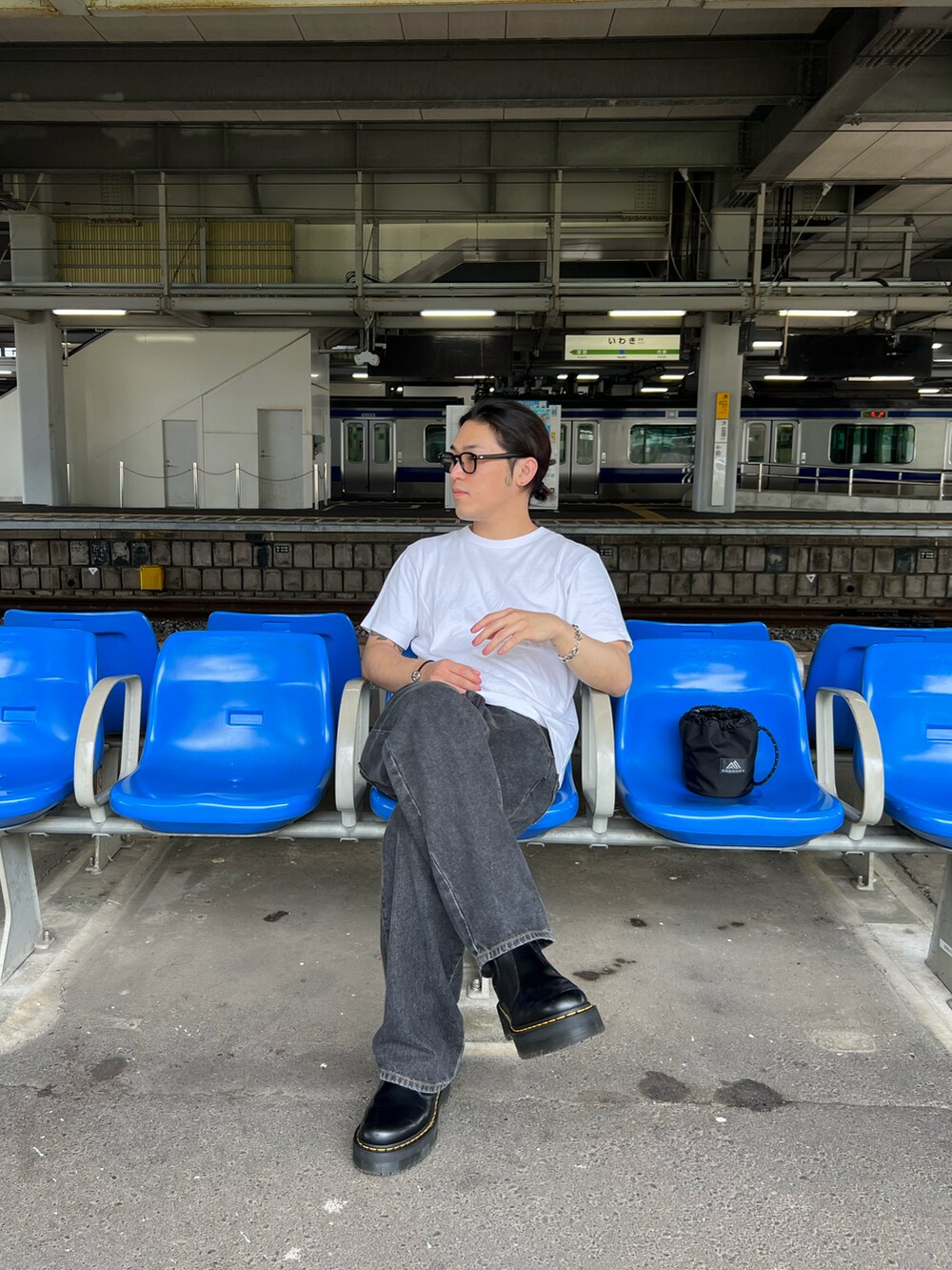 ホワイト系のTシャツ/カットソー、グレー系のデニムパンツ、ブラック系のブーツを着用したメンズの冬コーディネートの2枚目の写真