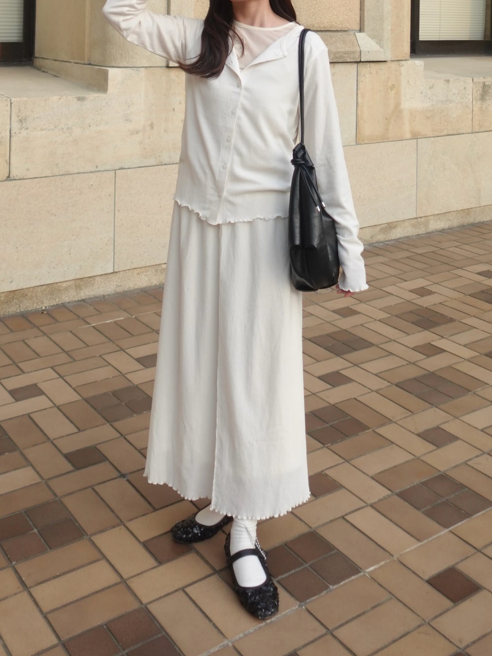 ホワイト系のカーディガン/ボレロ、ホワイト系のTシャツ/カットソー、ホワイト系のスカートを着用したレディースの春コーディネートの2枚目の写真