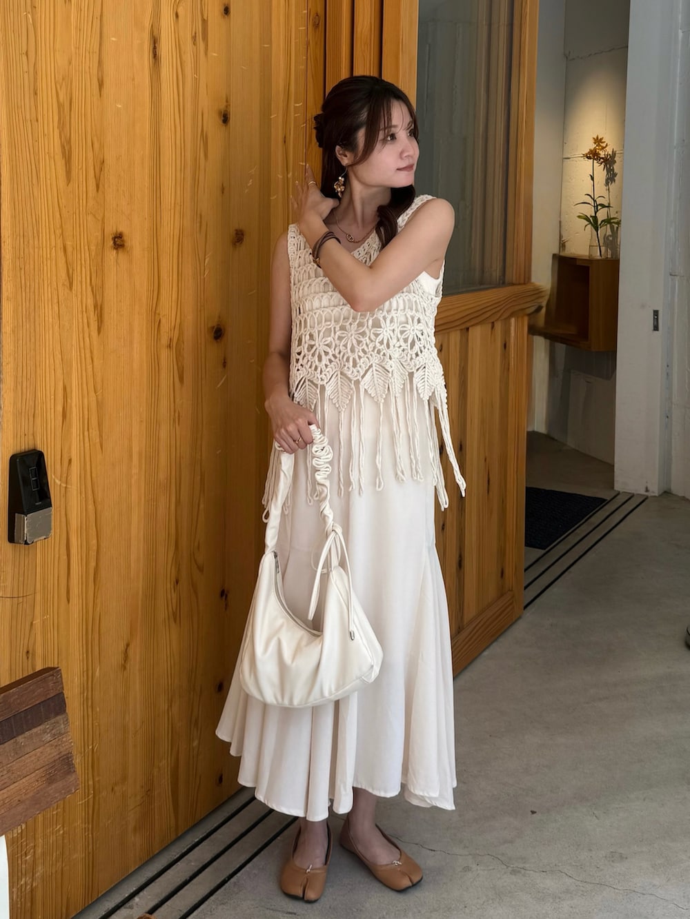 ホワイト系のスカート、ホワイト系のショルダーバッグ、イエロー系のバレエシューズを着用したレディースの夏コーディネートの3枚目の写真