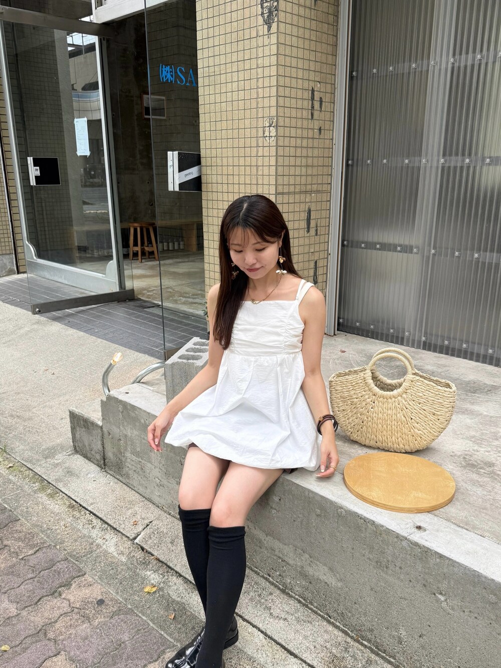 ホワイト系のワンピース、ホワイト系のかごバッグ、ブラック系のローファーを着用したレディースの夏コーディネートの2枚目の写真