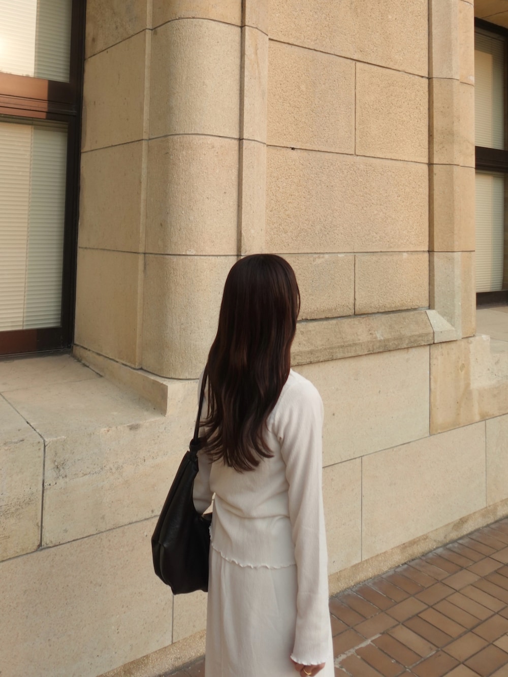 ホワイト系のカーディガン/ボレロ、ホワイト系のTシャツ/カットソー、ホワイト系のスカートを着用したレディースの春コーディネートの4枚目の写真