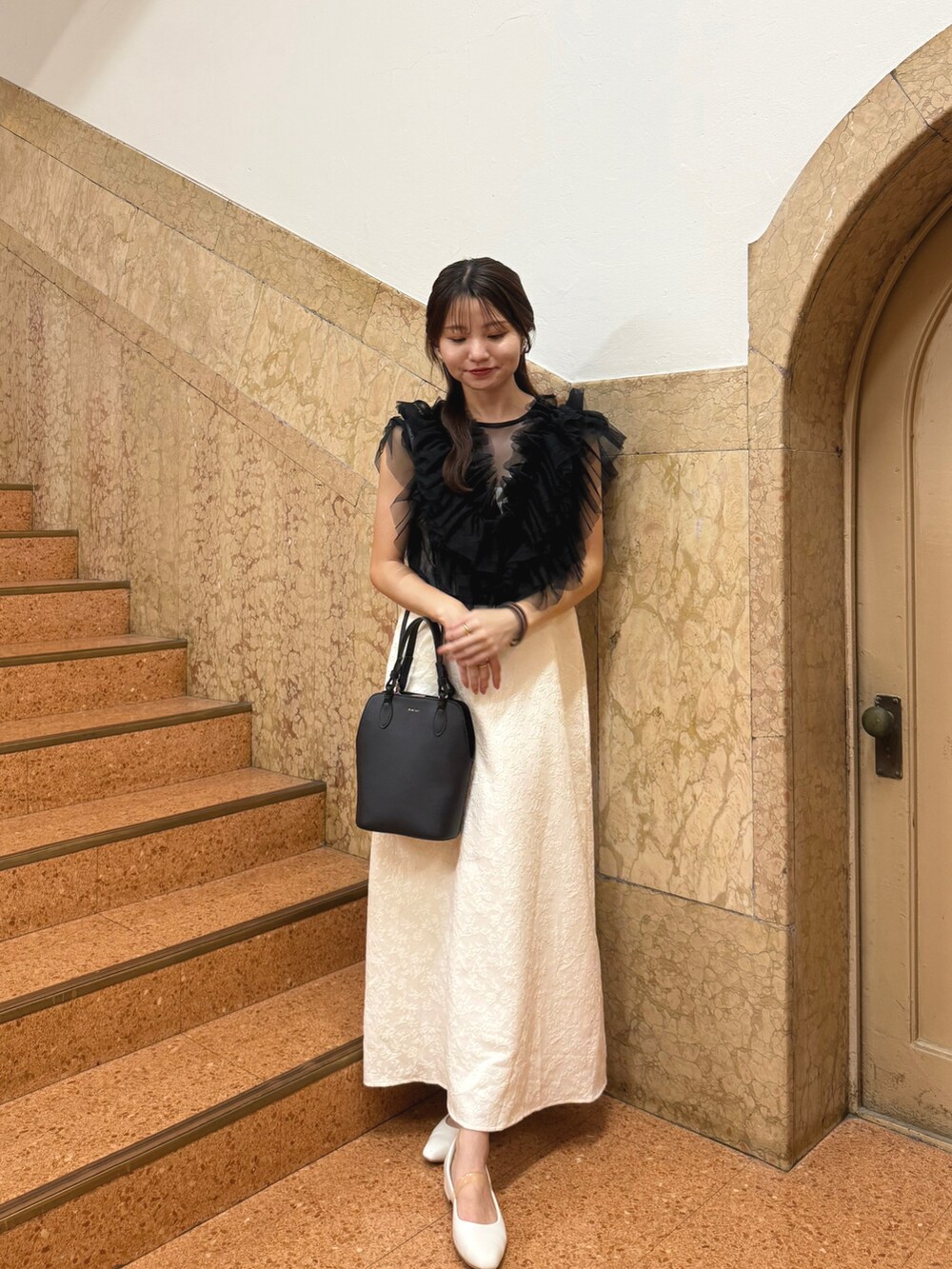 ホワイト系のワンピース、ブラック系のハンドバッグ、ブラック系のワンピース/ドレスを着用したレディースの夏コーディネートの2枚目の写真