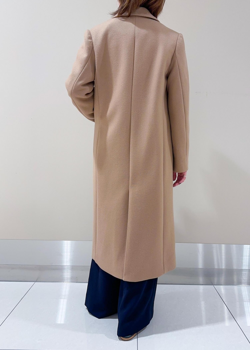 ブラック系のトートバッグ、イエロー系のチェスターコート、ブラウン系のニット/セーターを着用したレディースの秋コーディネートの6枚目の写真